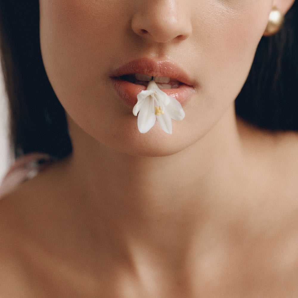 Close-up campaign image from LENY Summer collection featuring a white flower detail.